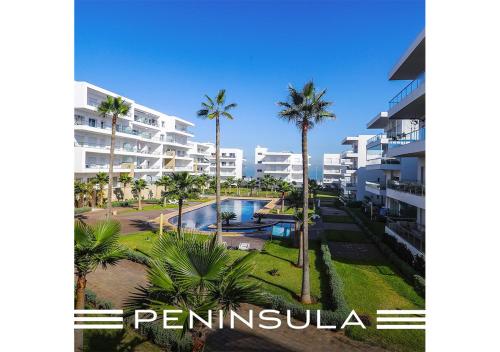 an aerial view of a resort with palm trees and a pool at Peninsula Dar Bouazza Superbe appartement en résidence avec piscine activités in Dar Bouazza