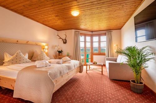 ein großes Schlafzimmer mit einem großen Bett und einem Sofa in der Unterkunft Hotelresort Klopeinersee in Sankt Kanzian am Klopeiner See