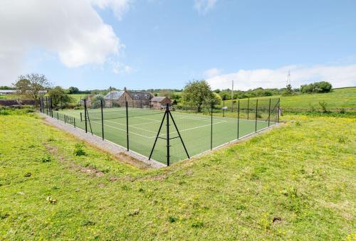 a tennis court in the middle of a field at Lower Fifehead Farm in Sturminster Newton