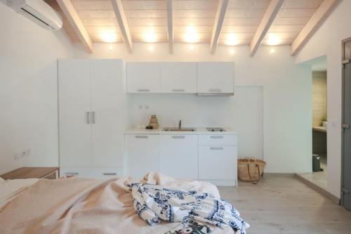 a white kitchen with a bed and a sink at Liberte Maisonettes in Parga