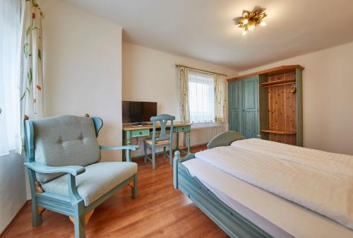 a bedroom with a bed and a desk and a chair at Chalet Haider in Saalbach Hinterglemm