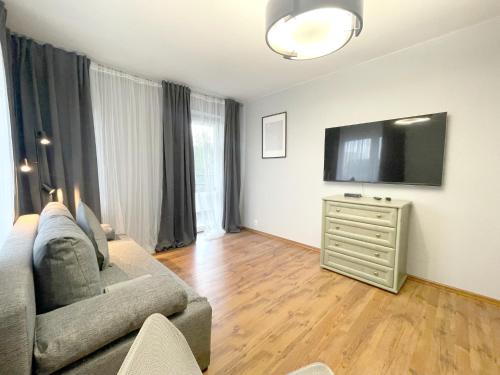 ein Wohnzimmer mit einem Sofa und einem Flachbild-TV in der Unterkunft 11 Gdynia Morska - Apartament Mieszkanie dla 5 osób in Gdynia