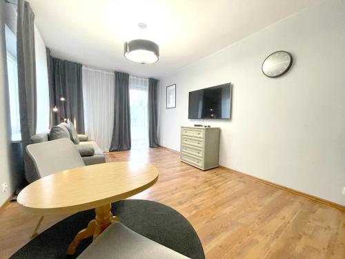 sala de estar con mesa y TV en 11 Gdynia Morska - Apartament Mieszkanie dla 5 osób, en Gdynia