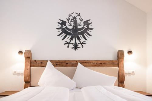 a bedroom with a bed with a crest on the wall at MYALPS Mühlhof in Oetz