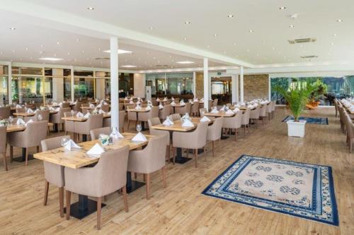 a restaurant with tables and chairs in a building at Promenaden-Strandhotel Marolt in Sankt Kanzian