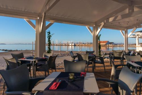 a restaurant on the beach with tables and chairs at Hotel Ibersol Atrio del Mar in Los Alcázares