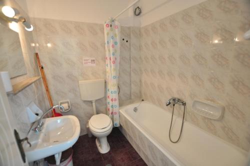 uma casa de banho com um WC, uma banheira e um lavatório. em Antigoni Apartments em Acharavi