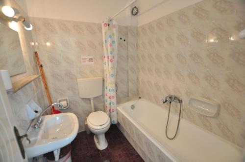 a bathroom with a toilet and a tub and a sink at Antigoni Apartments in Acharavi