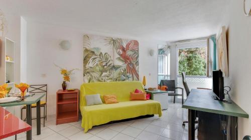 - un salon avec un canapé jaune et une télévision dans l'établissement Le 007 - Charmant studio Perpignan Sud, à Perpignan
