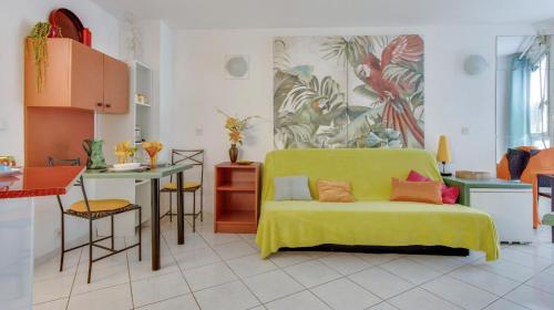 un salon avec un canapé jaune et une cuisine dans l'établissement Le 007 - Charmant studio Perpignan Sud, à Perpignan