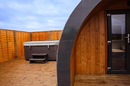 a large wooden deck with a hot tub and a hot tub at Fulshaw Mill Holidays in Stewarton