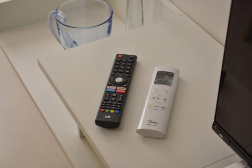 two remote controls sitting on top of a table at Welc-oM Casa Anna in Padova