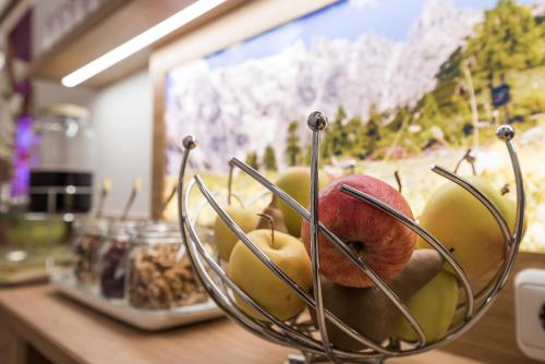 ein Korb mit Äpfeln und anderen Früchten auf einem Tisch in der Unterkunft Portis Appartements in Dienten am Hochkönig