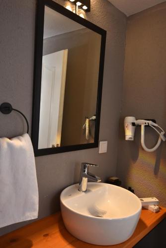 a bathroom with a white sink and a mirror at Benjamin Otel Gumusluk in Gumusluk