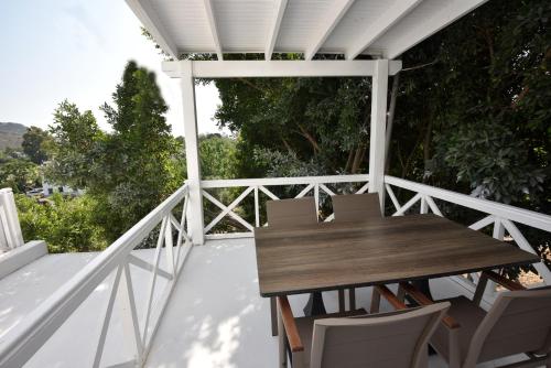 a wooden table and chairs on a balcony at Benjamin Otel Gumusluk in Gumusluk