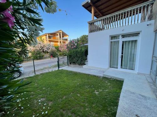 a white house with a fence and a yard at Apartments Pericic in Sutomore