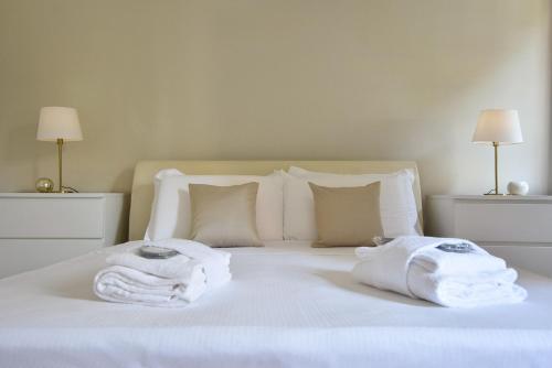 a white bed with towels on top of it at Welc-oM Casa Anna in Padova