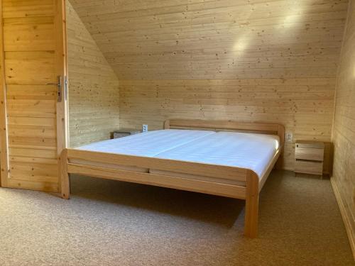 a bedroom with a bed in a wooden room at Chalupa Nella II. in Velké Karlovice