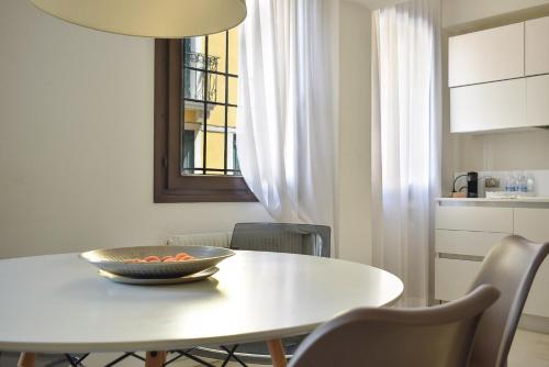 a white dining room table with a bowl on it at Welc-oM Casa Anna in Padova