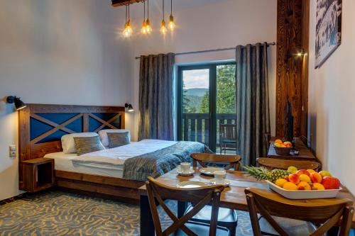 um quarto com uma cama e uma mesa com uma tigela de fruta em Strachan Family Jasná em Demanovska Dolina