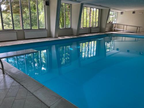 uma grande piscina com água azul em STUPENDO 3 CAMERE, PISCINA, BOX, VICINISSIMO PISTE em Prato Nevoso
