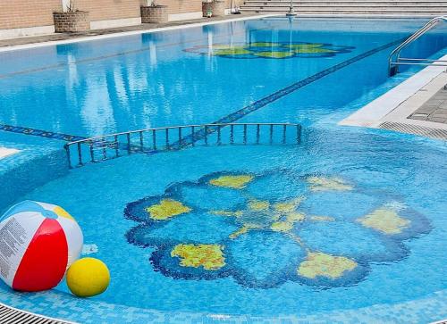 una piscina con due palline in acqua di Hotel Miramare Chioggia Sottomarina con PISCINA a Sottomarina