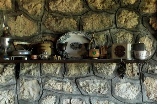 a shelf on a stone wall with items on it at Rent House Orahovo in Virpazar