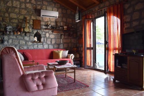 uma sala de estar com um sofá vermelho e uma mesa em Rent House Orahovo em Virpazar