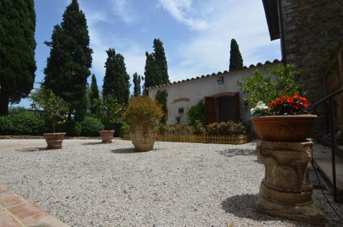 um pátio com vasos de plantas em frente a um edifício em Agriturismo La Torre dell'Oliveto em Agello