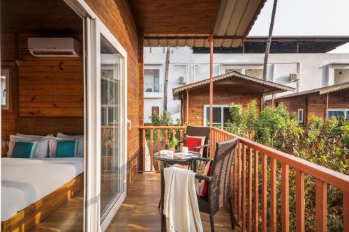 a balcony with a bed and a table at Mariners Bay Beach Resort in Arambol