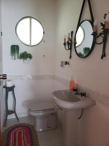 a bathroom with a sink and a toilet and a mirror at Sitio Natividade in Delfim Moreira
