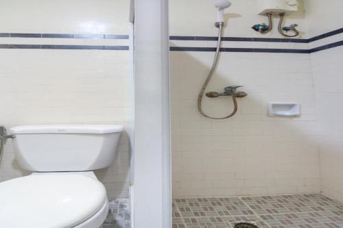 a bathroom with a toilet and a shower at OYO 166 Maanyag Pension House in Cebu City
