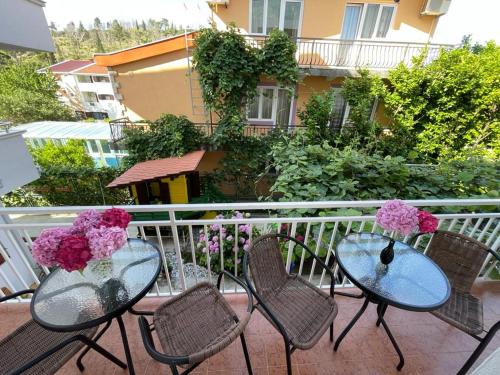 a balcony with two tables and chairs with flowers on them at Apartments Pericic in Sutomore