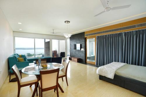 una camera con letto e una sala da pranzo con tavolo di St Jacinto Island Villa By JadeCaps- Bay View and Infinity Pool Near Goa Airport a Dabolim