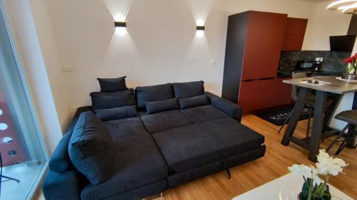 ein Wohnzimmer mit einem schwarzen Sofa und einem Tisch in der Unterkunft Apartment Ozare in Slovenj Gradec