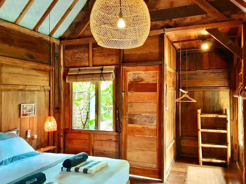 a bedroom with a bed and a chandelier at Musa Bintang Villas and Bungalows Gili Air in Gili Air