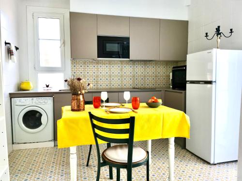 kuchnia ze stołem z żółtą tkaniną w obiekcie Petit Appartement dans une maison w Bajonnie