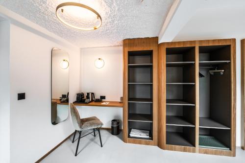 a room with a desk and a chair and a mirror at Boutique Hotel La Gorge in Saas-Fee