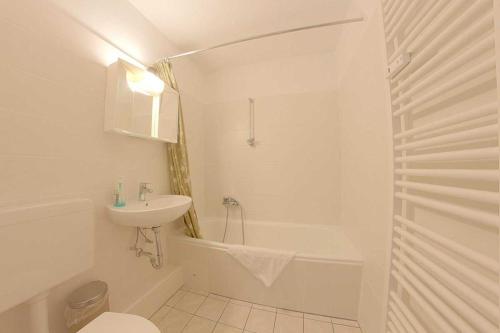 ein weißes Badezimmer mit einem Waschbecken, einer Badewanne und einem WC in der Unterkunft Apartment 261 in Hohegeiß