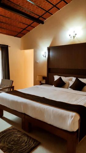 a bedroom with a large bed with a large headboard at BADAMI HERITAGE RESORT in Badami