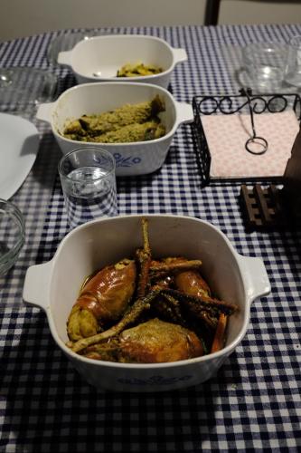 Eine Pfanne mit Hühnchen und anderen Speisen auf einem Tisch in der Unterkunft PARUL - Elegant Heritage Home at the Heart of Shantiniketan in Shānti Niketan
