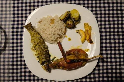 einen Teller mit Reis und Gemüse auf dem Tisch in der Unterkunft PARUL - Elegant Heritage Home at the Heart of Shantiniketan in Shānti Niketan