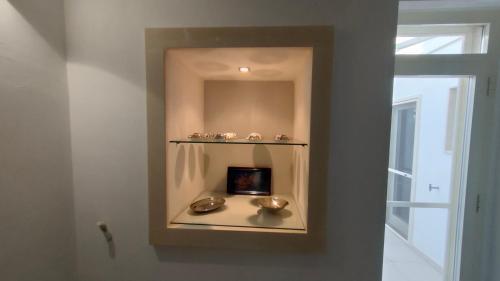 a room with a shelf with bowls and a mirror at Dimora Giorgilla in Martano