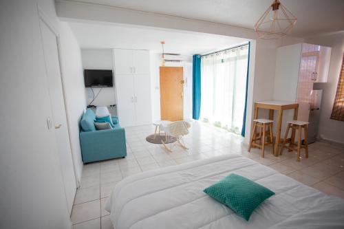 a bedroom with a bed and a living room at BOULEVARD LEGITIMUS in Pointe-à-Pitre