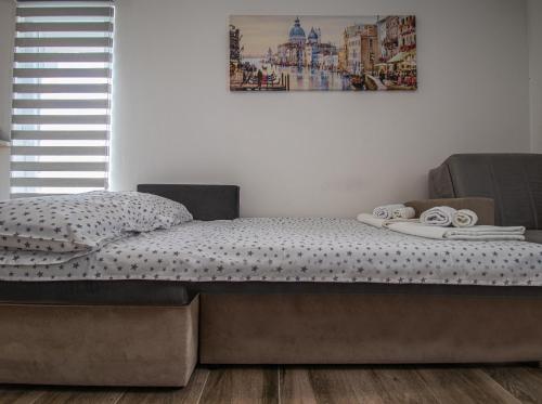 un letto in una camera da letto con una foto sul muro di Studio Apartment Urke a Budua