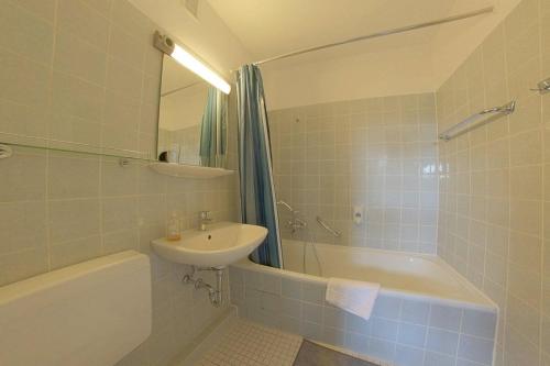 een badkamer met een wastafel, een toilet en een bad bij Apartment 449 in Hohegeiß