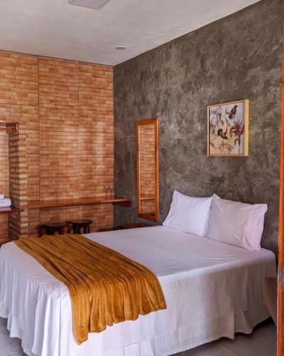 a bedroom with a large bed with a brown blanket on it at Casa do Tchesko in Viçosa do Ceará