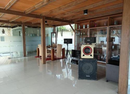 una gran sala de estar con una habitación con TV en The Kulawi Villa & Resort, en Puncak
