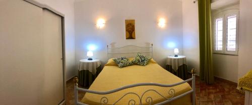 een slaapkamer met een bed met twee lampjes aan de muur bij SOLAR DOS AVÓS in Guia
