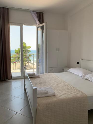 a bedroom with a bed with a view of the ocean at Sunny Breeze Shengjin in Shëngjin